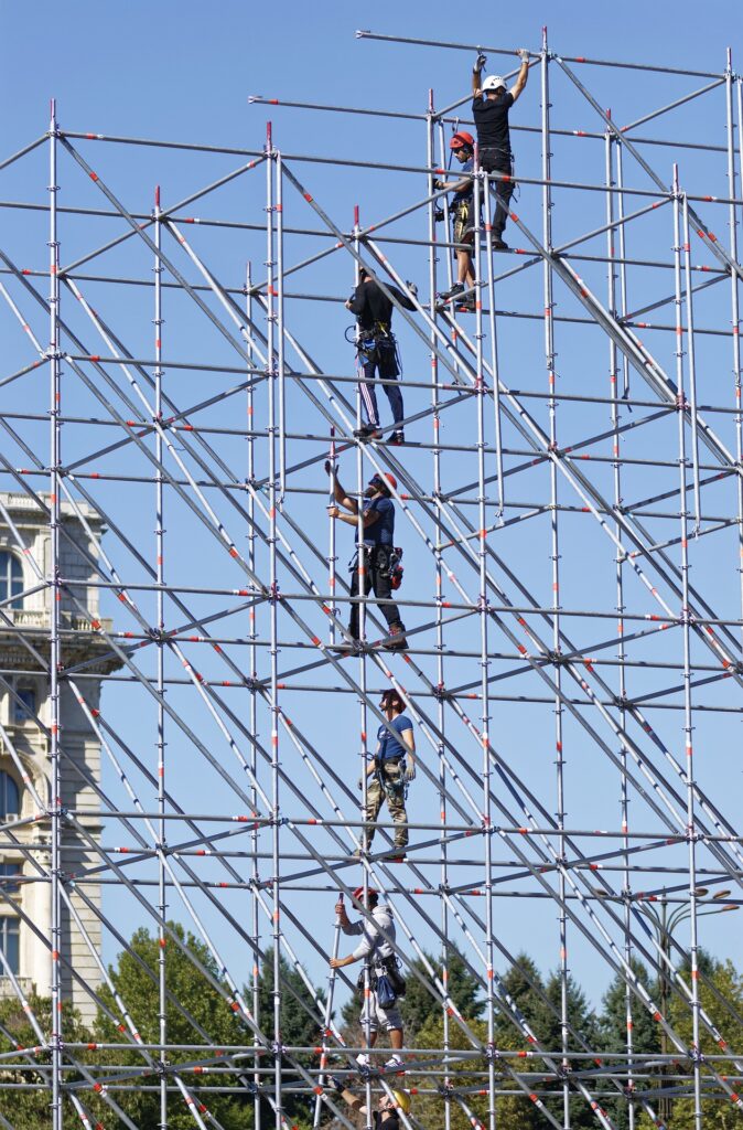 Workers standing in a scaffolding